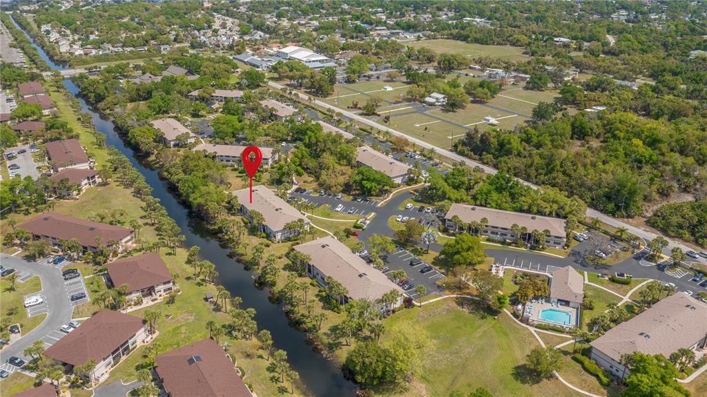 An aerial view shows a multi-family residential complex with a canal and parking lots — 1515 FORREST NELSON BOULEVARD UNIT L105, PORT CHARLOTTE, FL