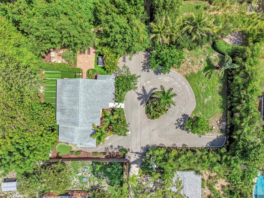 An aerial view shows a house with a circular driveway and lush surrounding landscaping — 2137 WORRINGTON STREET, SARASOTA, FL