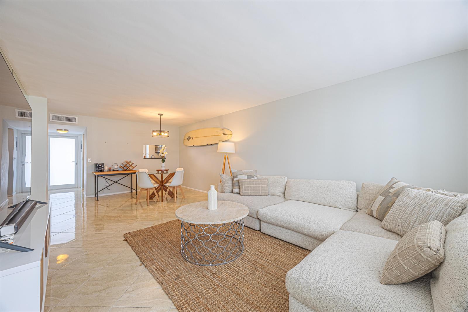 A living room features a sectional sofa, a round coffee table, and a dining area — 201 N Ocean Boulevard # 702, Pompano Beach FL 33062, POMPANO BEACH, FL