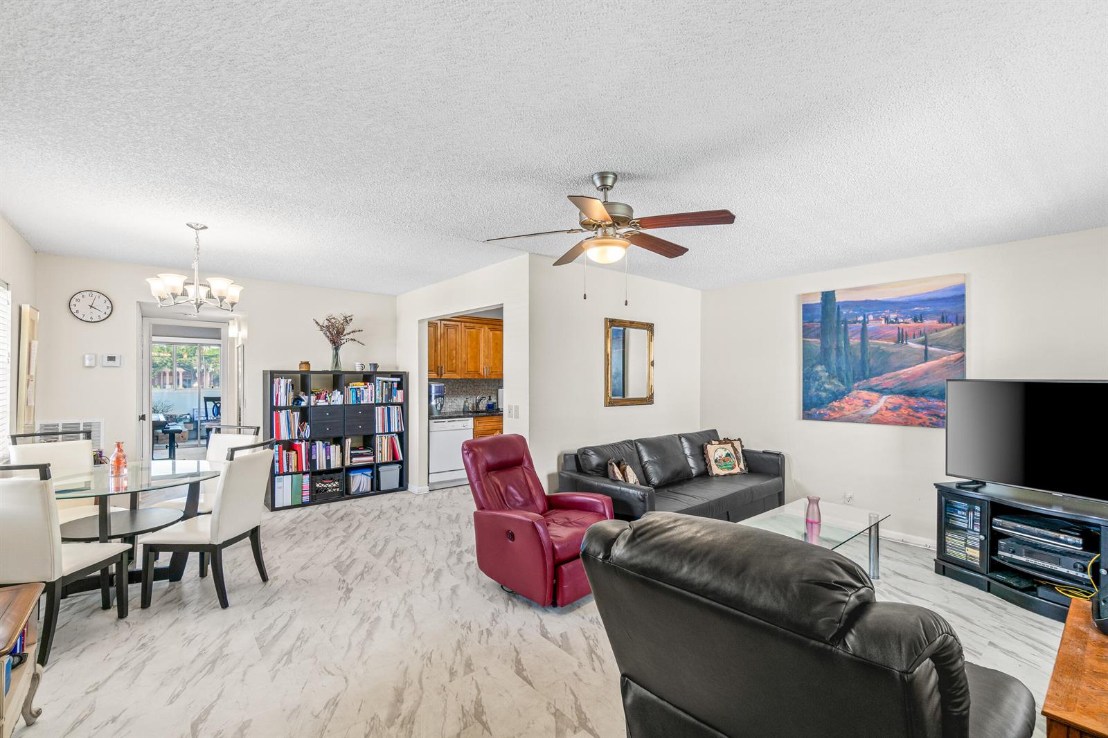 A living room and dining area with white marble-look flooring, a ceiling fan, and furniture — 184 Flanders D, Delray Beach FL 33484, DELRAY BEACH, FL