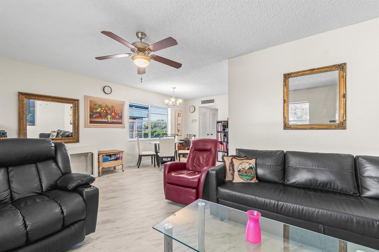 A living room with black leather furniture, a red recliner, and a dining area beyond — 184 Flanders D, Delray Beach FL 33484, DELRAY BEACH, FL
