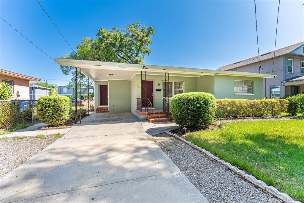 A light green single-story house features a concrete driveway, a carport, and a front lawn — 506 E SPARKMAN AVENUE, TAMPA, FL