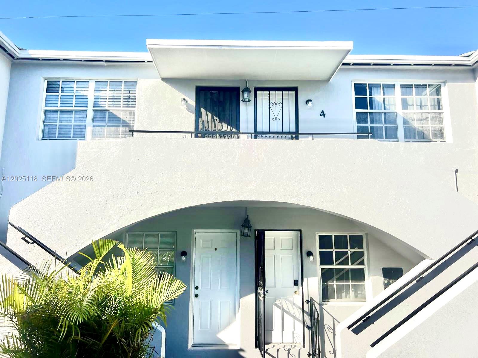 The exterior of a two-story apartment building features white stucco walls and a balcony — 2371 SW 27th St, Miami FL 33133, MIAMI, FL