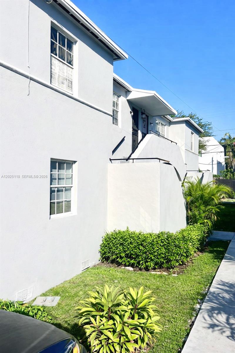 A two-story light-colored building features an exterior staircase leading to an upper-level entrance — 2371 SW 27th St, Miami FL 33133, MIAMI, FL