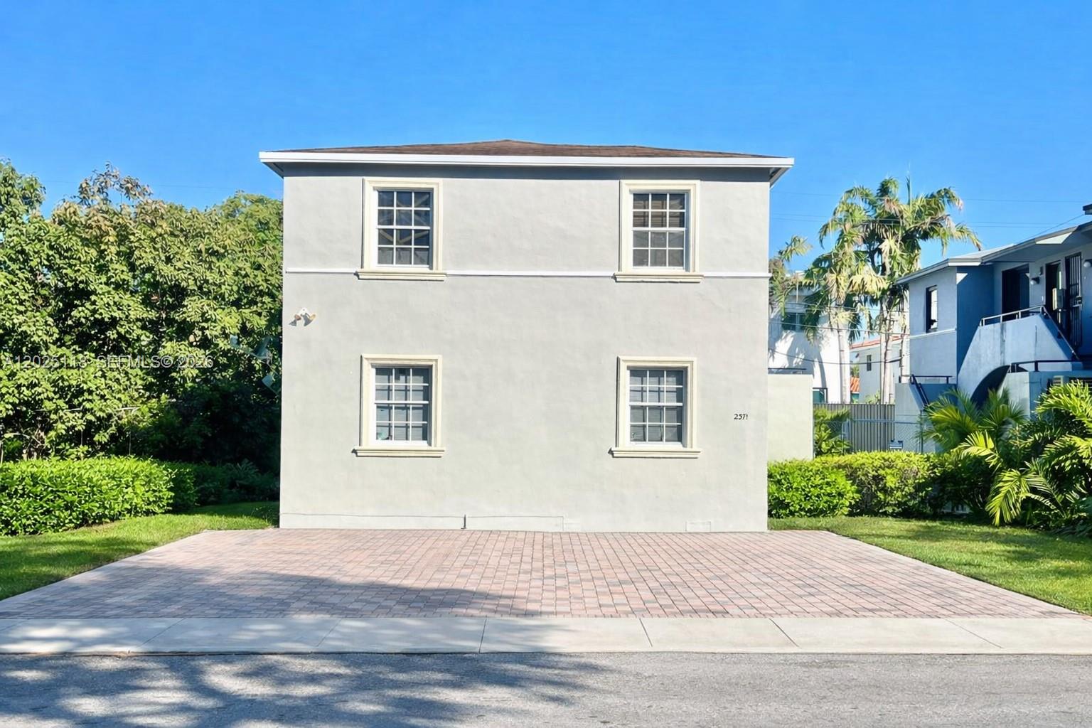 A two-story, light-gray stucco building features four windows and a paved brick driveway — 2371 SW 27th St, Miami FL 33133, MIAMI, FL