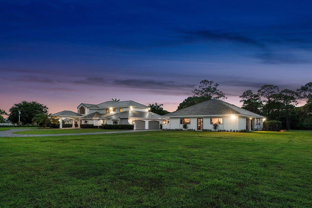 A large multi-story house with a separate garage building sits on a vast green lawn — 21677 El Bosque Way, Boca Raton FL 33428, BOCA RATON, FL