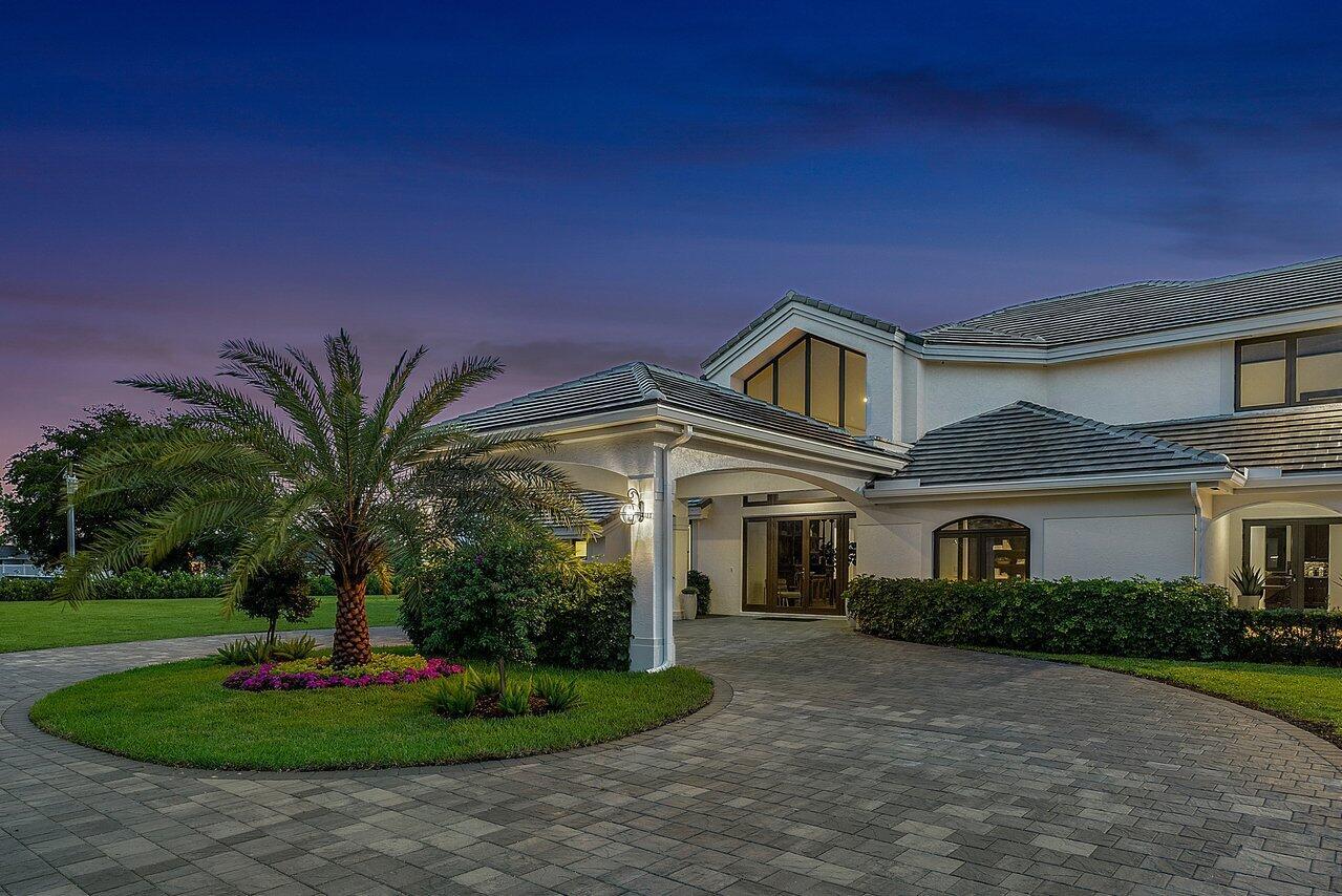 A paved circular driveway leads to the covered entrance of a two-story white house — 21677 El Bosque Way, Boca Raton FL 33428, BOCA RATON, FL