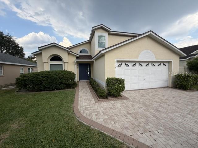 A two-story house with a beige stucco exterior, a paved driveway, and a front walkway — 13505 MALLARD COVE BLVD, ORLANDO, FL
