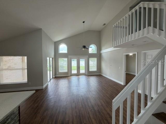 A spacious living room features vaulted ceilings, wood-look flooring, and a staircase to a loft — 13505 MALLARD COVE BLVD, ORLANDO, FL