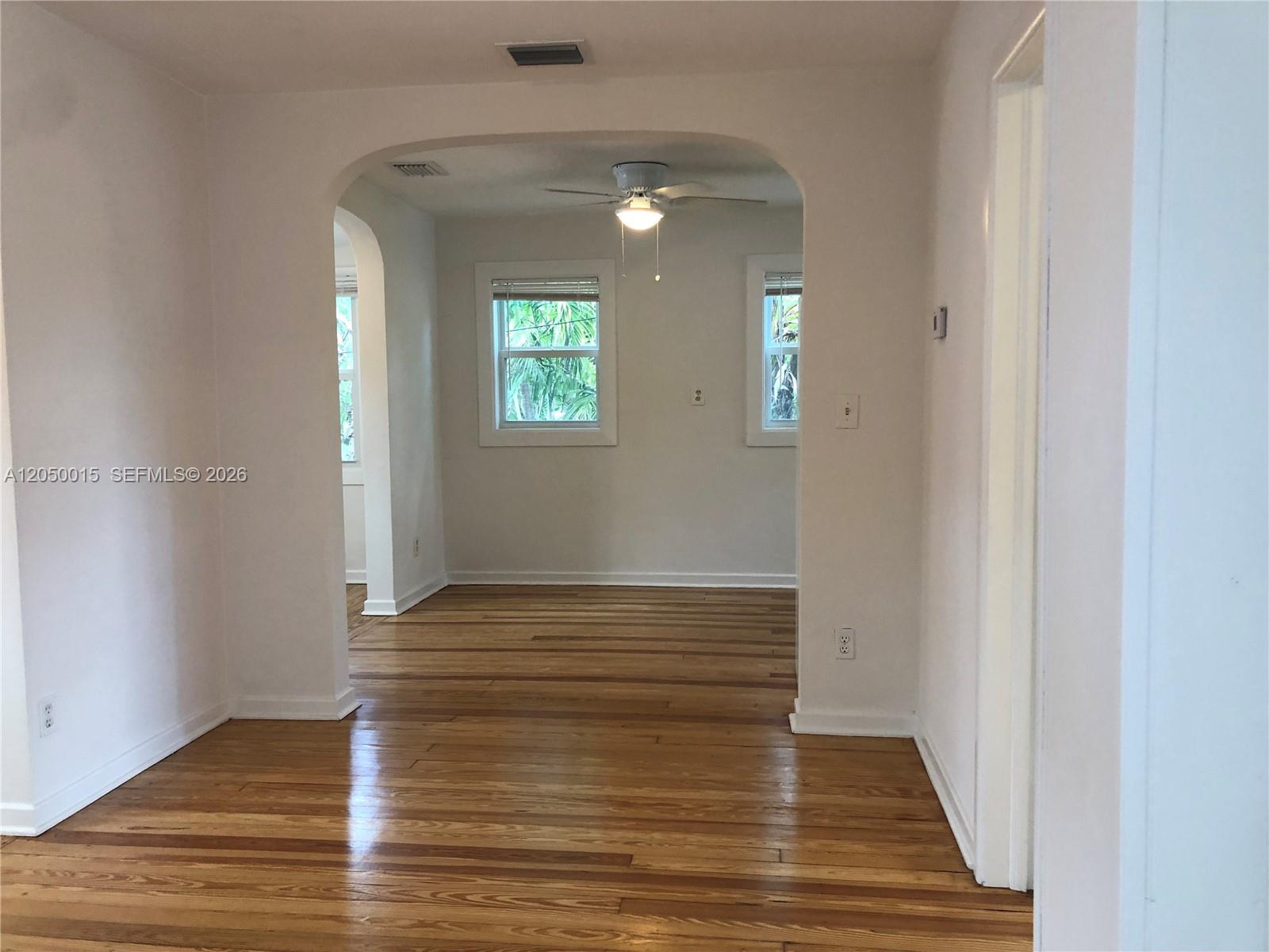 An interior view shows a room with hardwood floors and an arched doorway leading to another — 114 S M St # 5, Lake Worth FL 33460, LAKE WORTH, FL