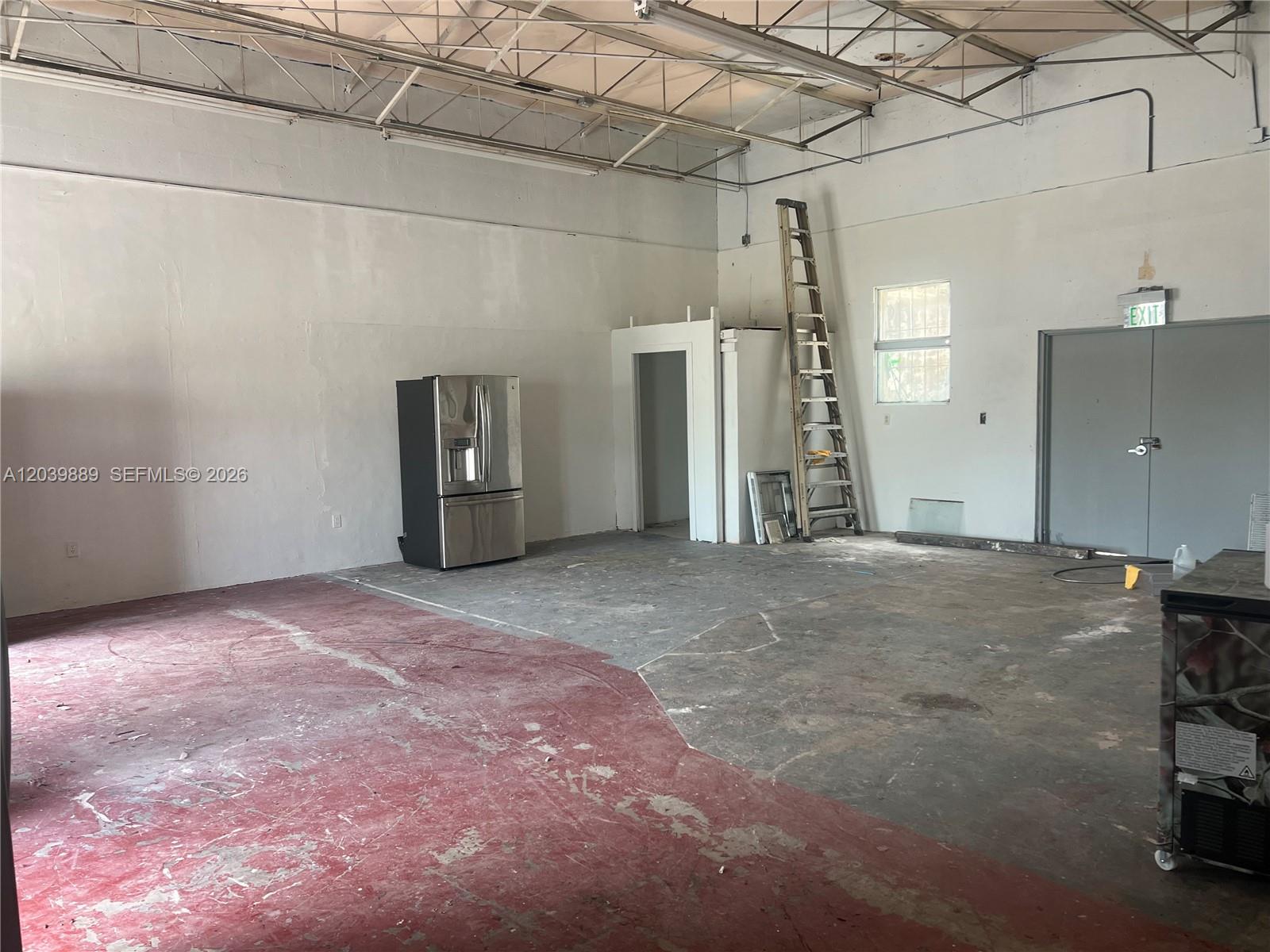 An industrial space features a concrete floor, a stainless steel refrigerator, and a tall ladder — 1325 E 10th Ave # 2, Hialeah FL 33010, HIALEAH, FL