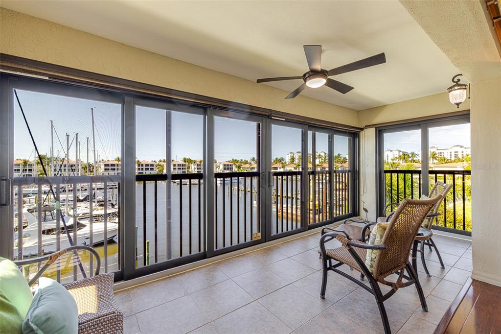 A covered balcony with tile flooring, a ceiling fan, and sliding doors overlooking a marina — 3235 SUGARLOAF KEY ROAD UNIT 13C, PUNTA GORDA, FL