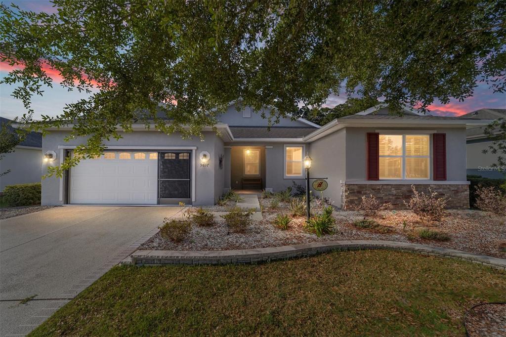 A single-story house with a gray stucco exterior, a two-car garage, and a landscaped yard — 9637 SW 95TH LOOP, OCALA, FL
