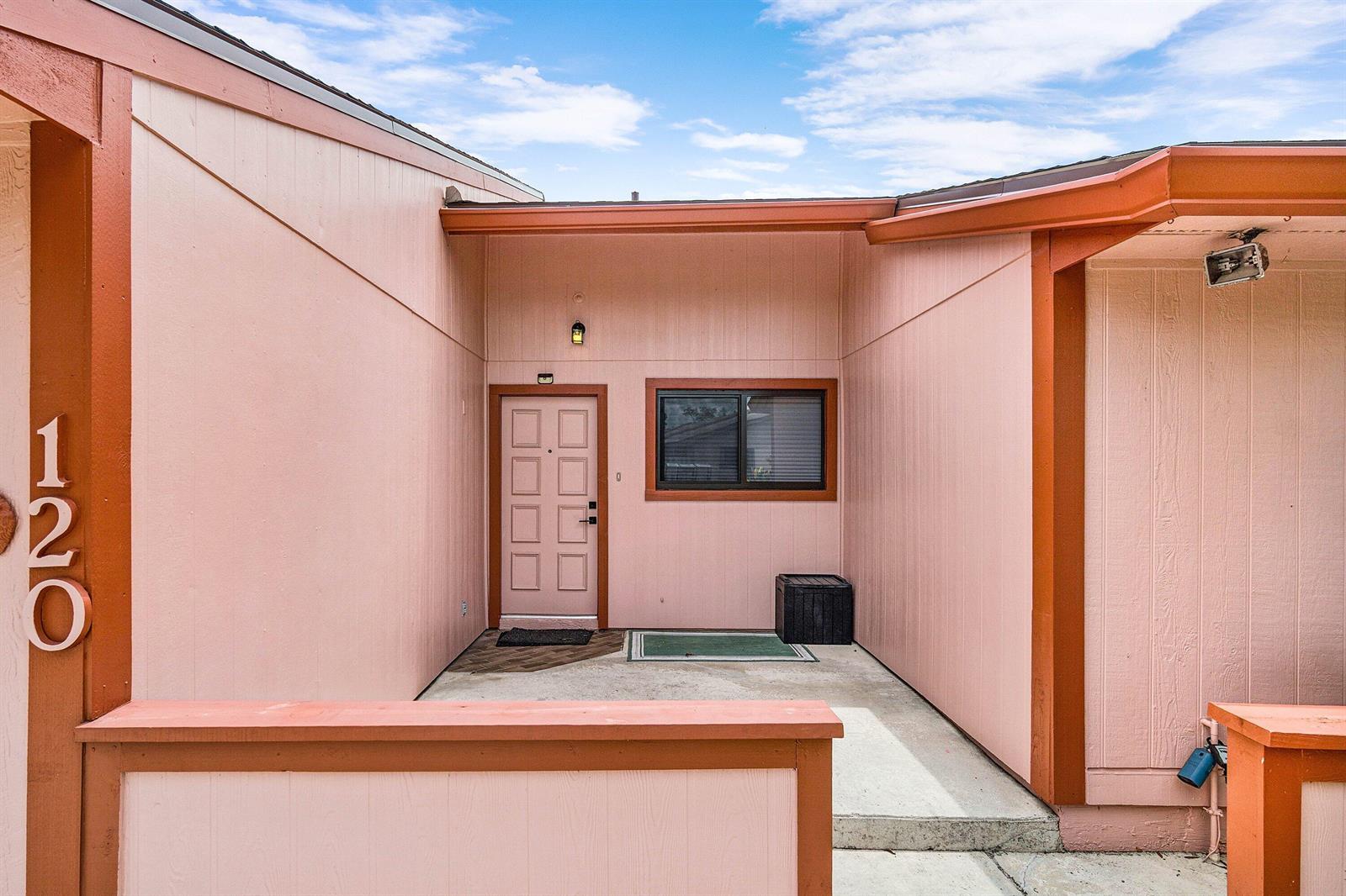 The exterior of a pink building features a front door, a window, and house number 120 — 120 Mayfair Lane, Boynton Beach FL 33426, BOYNTON BEACH, FL