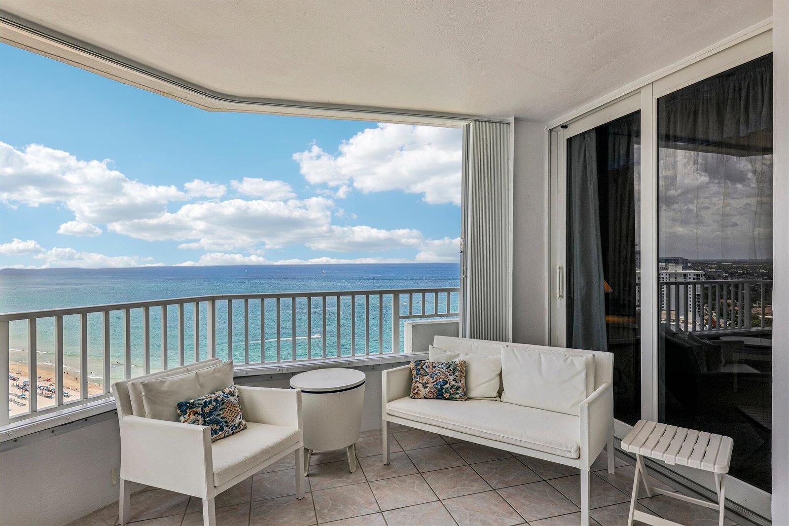A balcony with white patio furniture overlooks the ocean and a sandy beach — 1340 S Ocean Boulevard # 2303, Pompano Beach FL 33062, POMPANO BEACH, FL