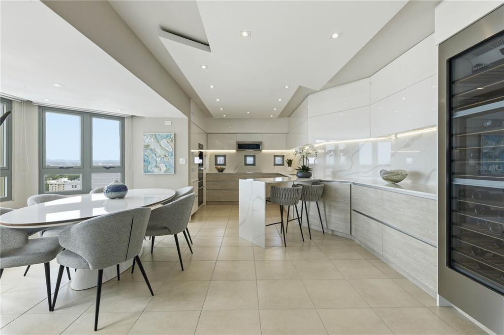 A modern kitchen and dining area features white cabinetry, marble countertops, and a wine cooler — 103-105 DE DIEGO AVENUE UNIT 1604S, SAN JUAN, PR