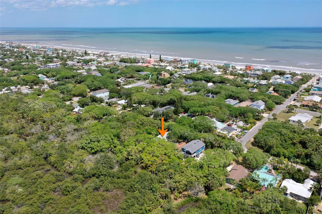An aerial view shows a coastal neighborhood with a house highlighted by an orange arrow — 1436 S FLAGLER AVENUE, FLAGLER BEACH, FL