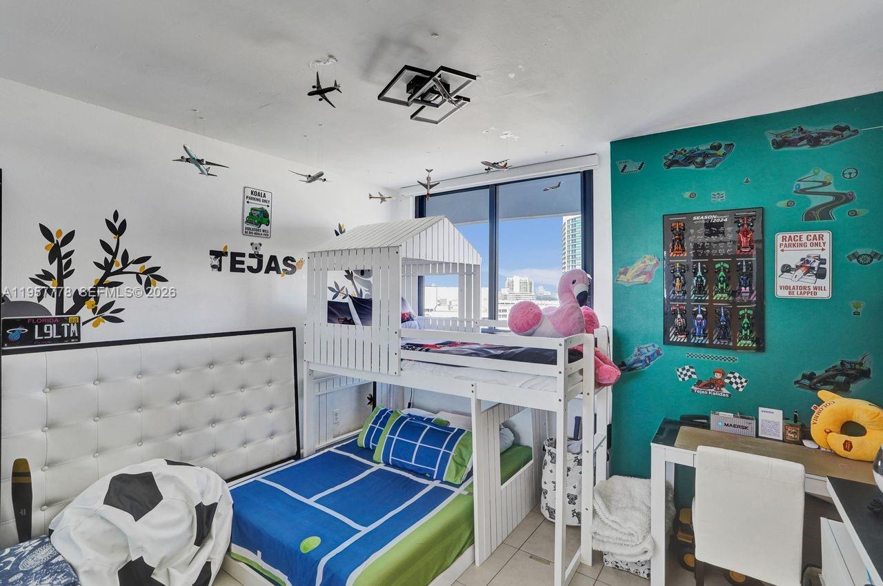 A child's bedroom features a white bunk bed, a desk, and walls decorated with racing themes — 1330 West Ave # 1811, Miami Beach FL 33139, MIAMI BEACH, FL
