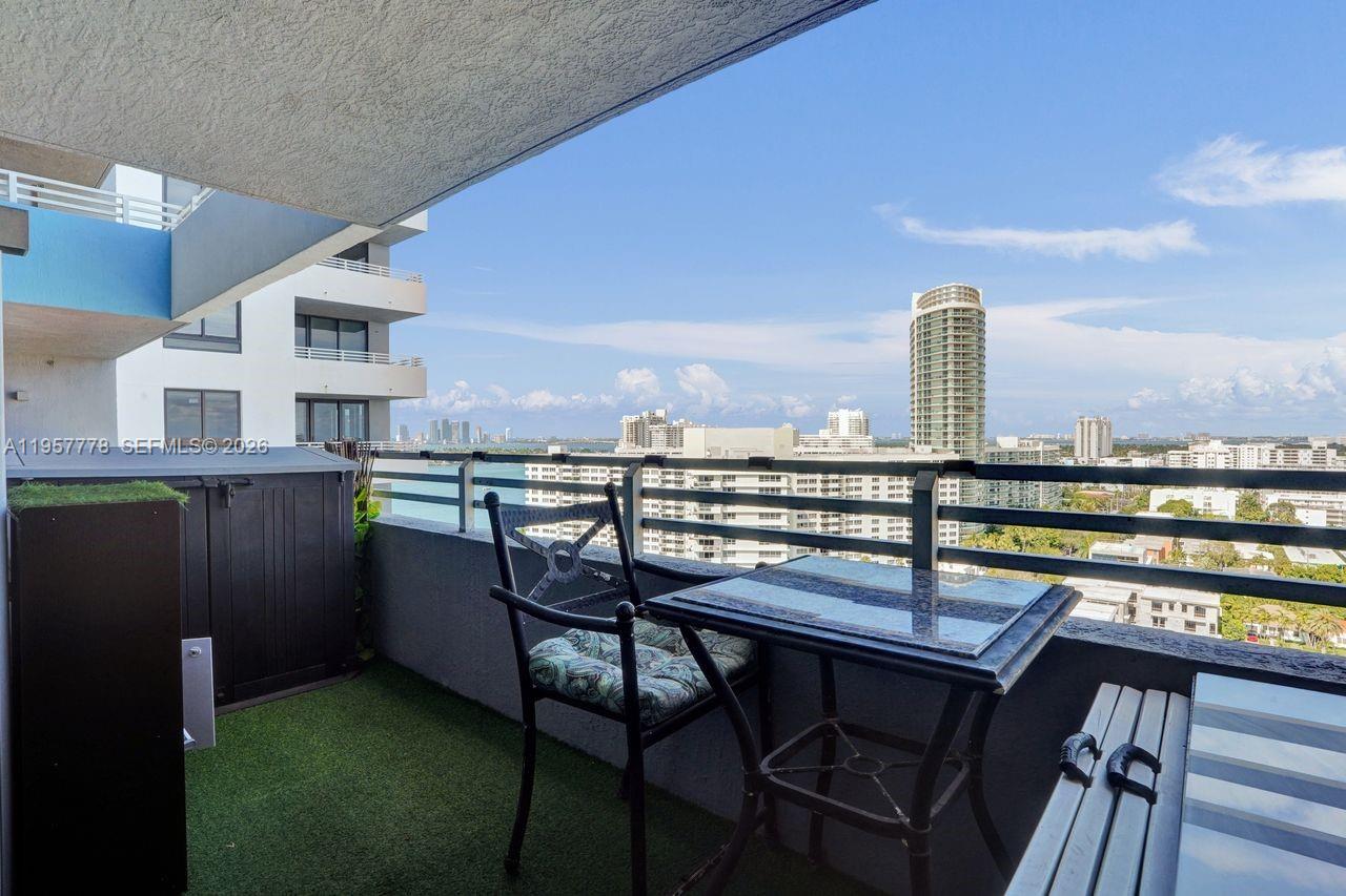 A balcony with artificial turf, patio furniture, and a view of city buildings and water — 1330 West Ave # 1811, Miami Beach FL 33139, MIAMI BEACH, FL