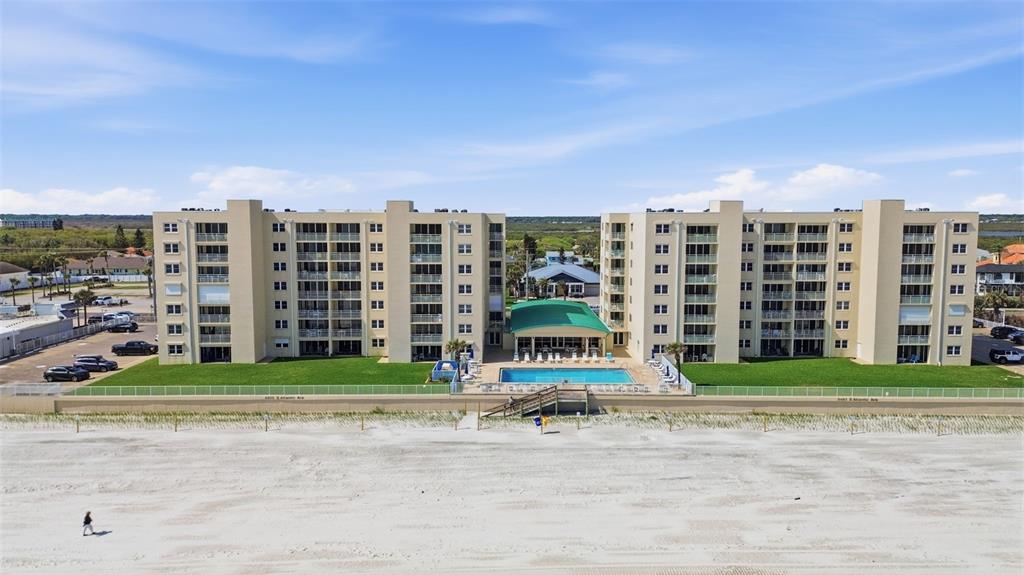 An aerial view of a multi-story beachfront condominium complex with a central swimming pool — 4495 S ATLANTIC AVENUE UNIT 501, PORT ORANGE, FL
