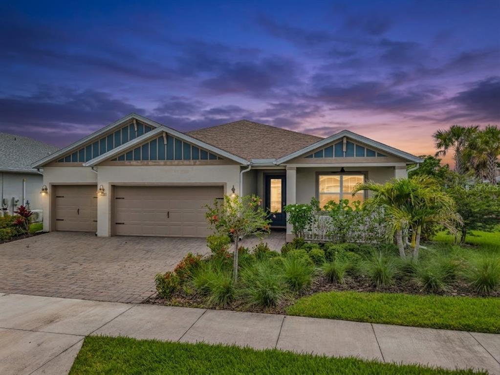 A single-story house with a two-car garage and a paved driveway at dusk — 16121 LOTUS WAY, PUNTA GORDA, FL