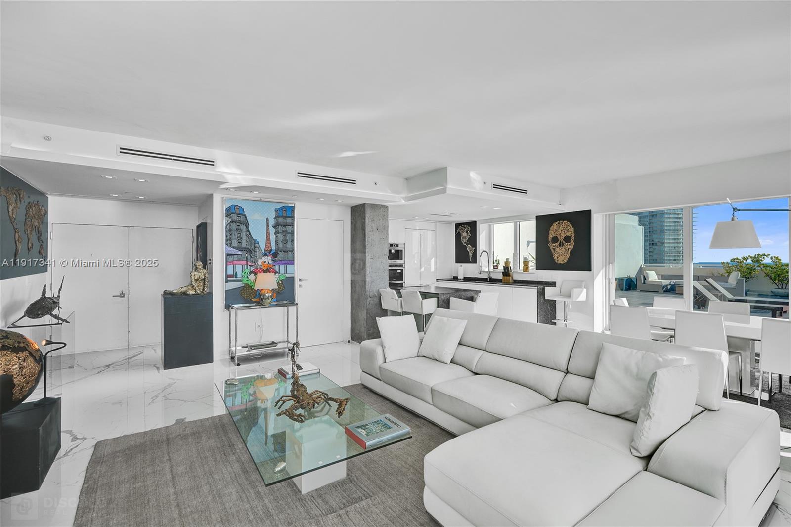 A modern living room features a white sectional sofa, marble floors, and a glass coffee table — 650 West Ave, Miami Beach FL 33139, MIAMI BEACH, FL
