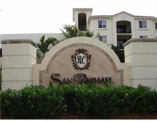 The exterior of a multi-story apartment building features a stone entrance sign with landscaping — 3 Renaissance Way # 204, Boynton Beach FL 33426, BOYNTON BEACH, FL