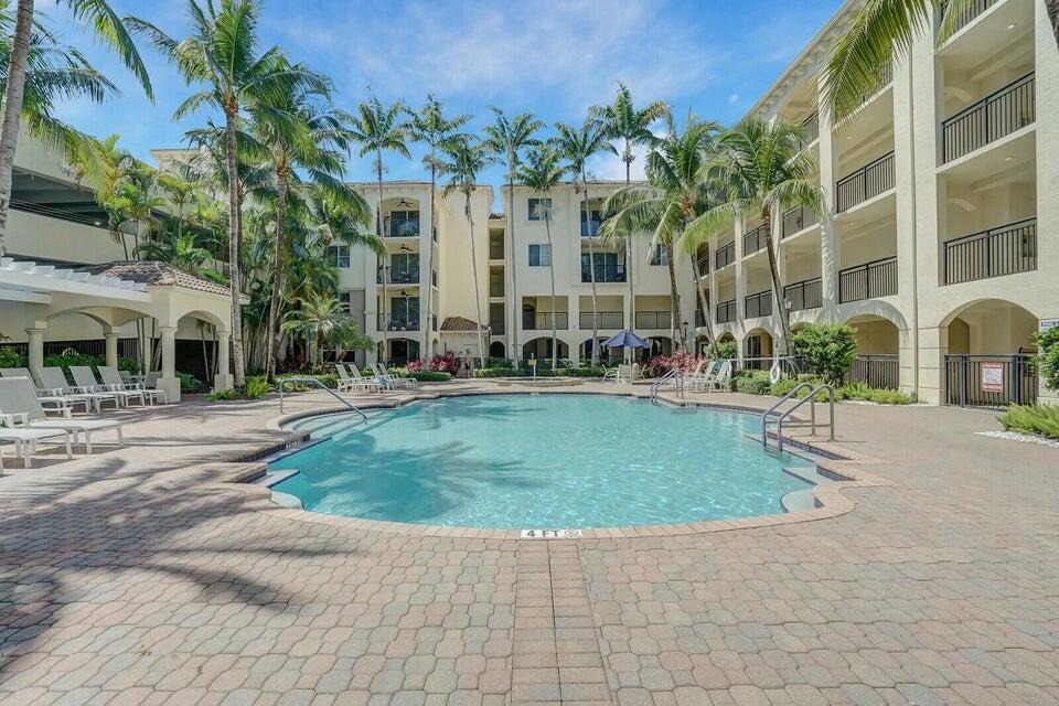 A swimming pool sits in the center of a courtyard surrounded by multi-story apartment buildings — 3 Renaissance Way # 204, Boynton Beach FL 33426, BOYNTON BEACH, FL