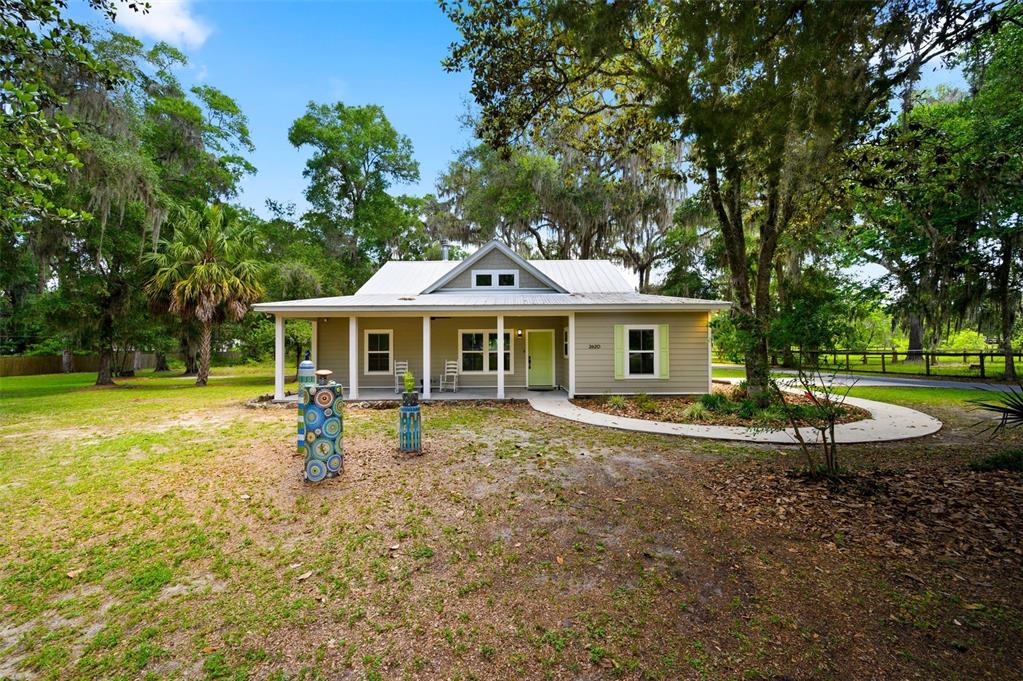 A one-story house with light siding, a metal roof, and a front porch — 2620 NW 31ST AVENUE, GAINESVILLE, FL