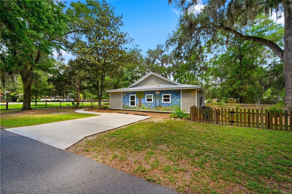 A single-story house with a mosaic mural on the exterior wall and a concrete driveway — 2620 NW 31ST AVENUE, GAINESVILLE, FL