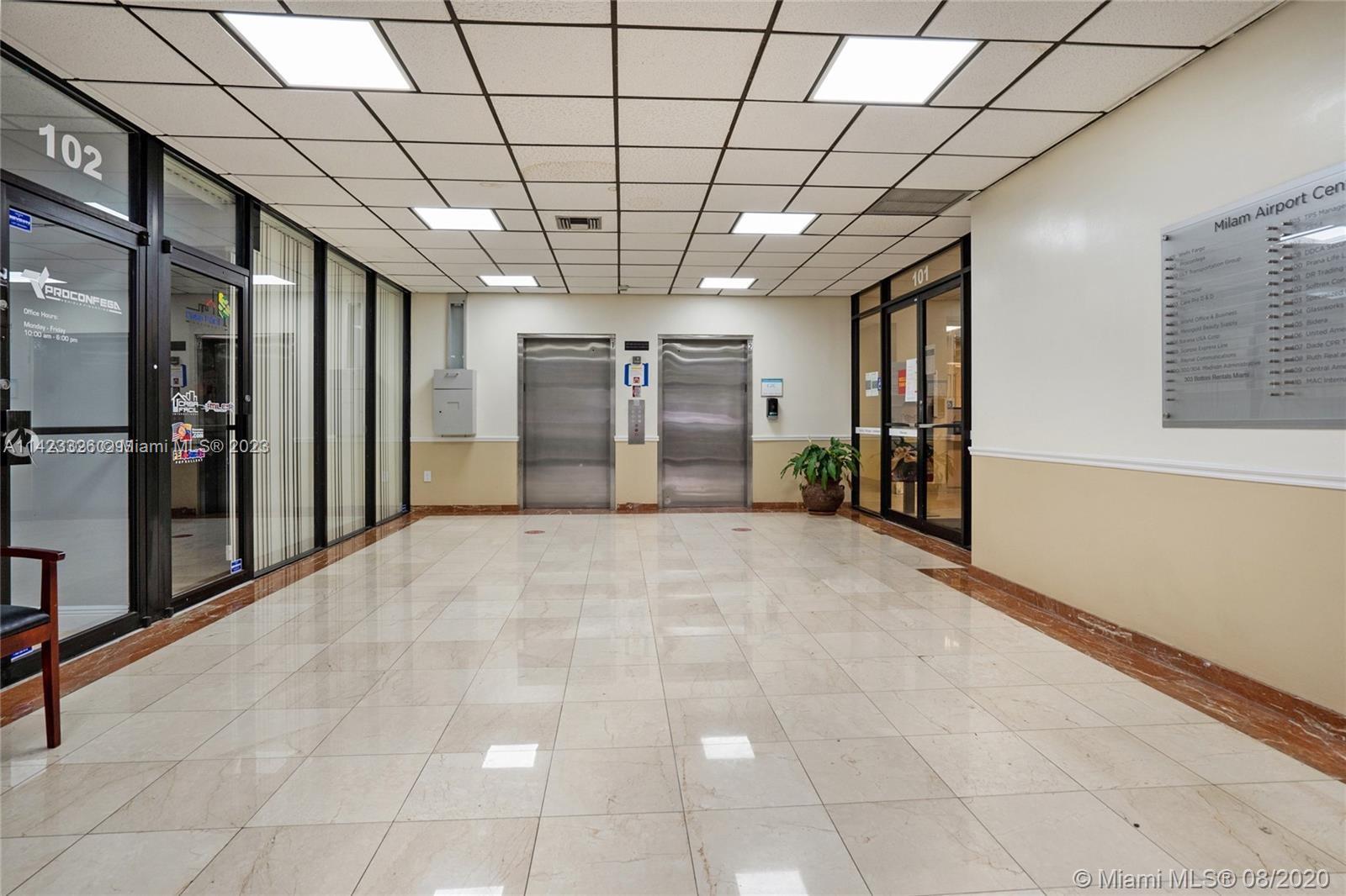 A commercial building lobby features tile flooring, two elevators, glass-paneled office doors, and a directory — 4995 NW 72nd Ave # 202, Miami FL 33166, MIAMI, FL
