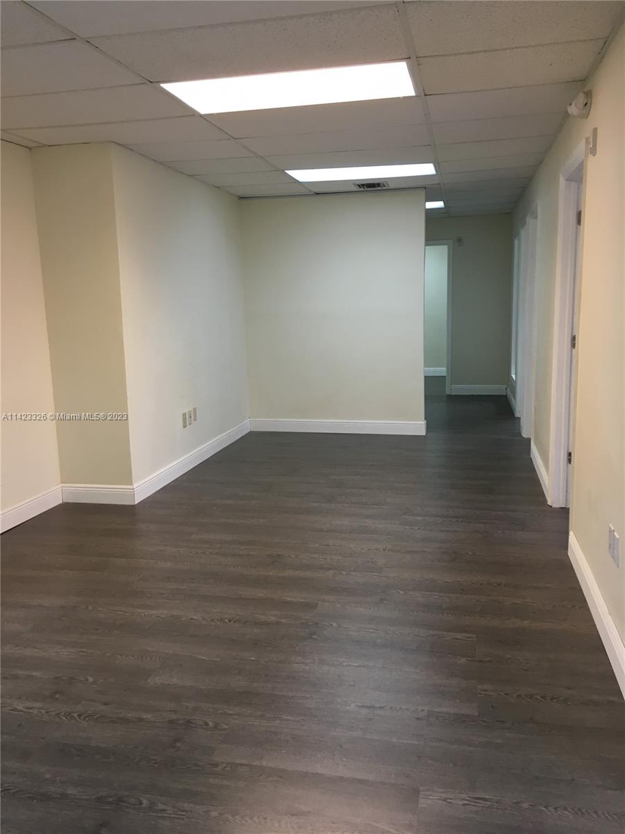 An empty office space features light-colored walls, a drop ceiling with recessed lighting, and dark wood-look flooring — 4995 NW 72nd Ave # 202, Miami FL 33166, MIAMI, FL