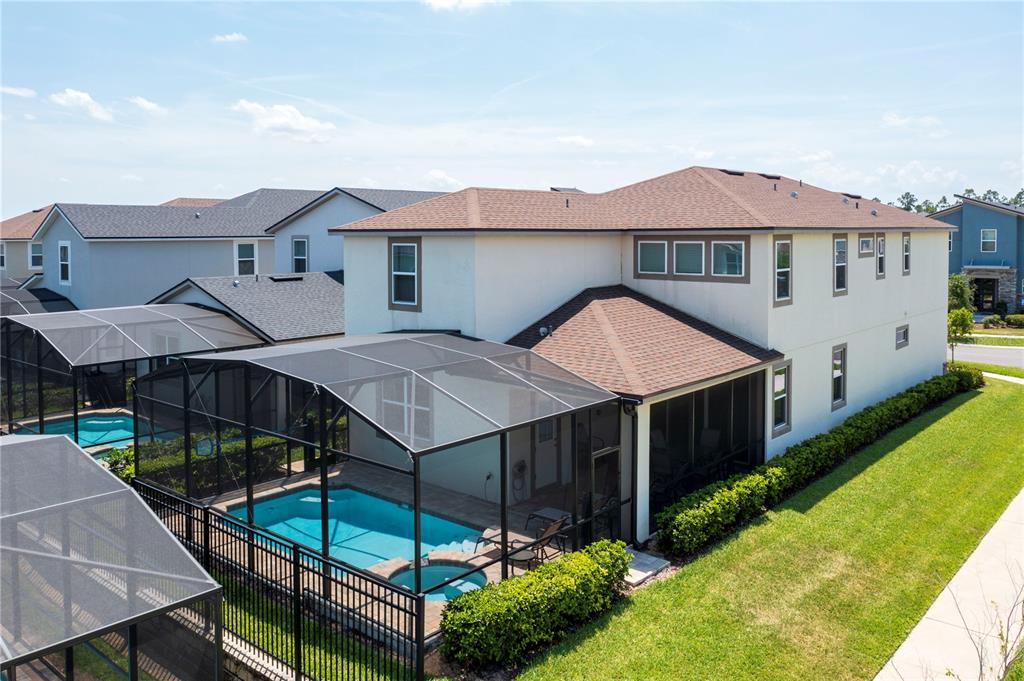 An aerial view of a two-story house with a screened-in pool and patio — 9039 PELICAN COVE TRACE, KISSIMMEE, FL