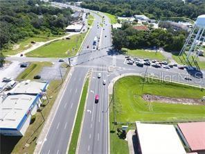 An aerial view shows a multi-lane intersection with surrounding commercial buildings and a water tower — E. NORTH BLVD (US HWY 441), LEESBURG, FL