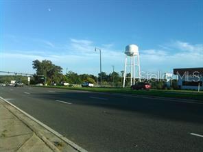 A view of a multi-lane road with a large white water tower in the background — E. NORTH BLVD (US HWY 441), LEESBURG, FL