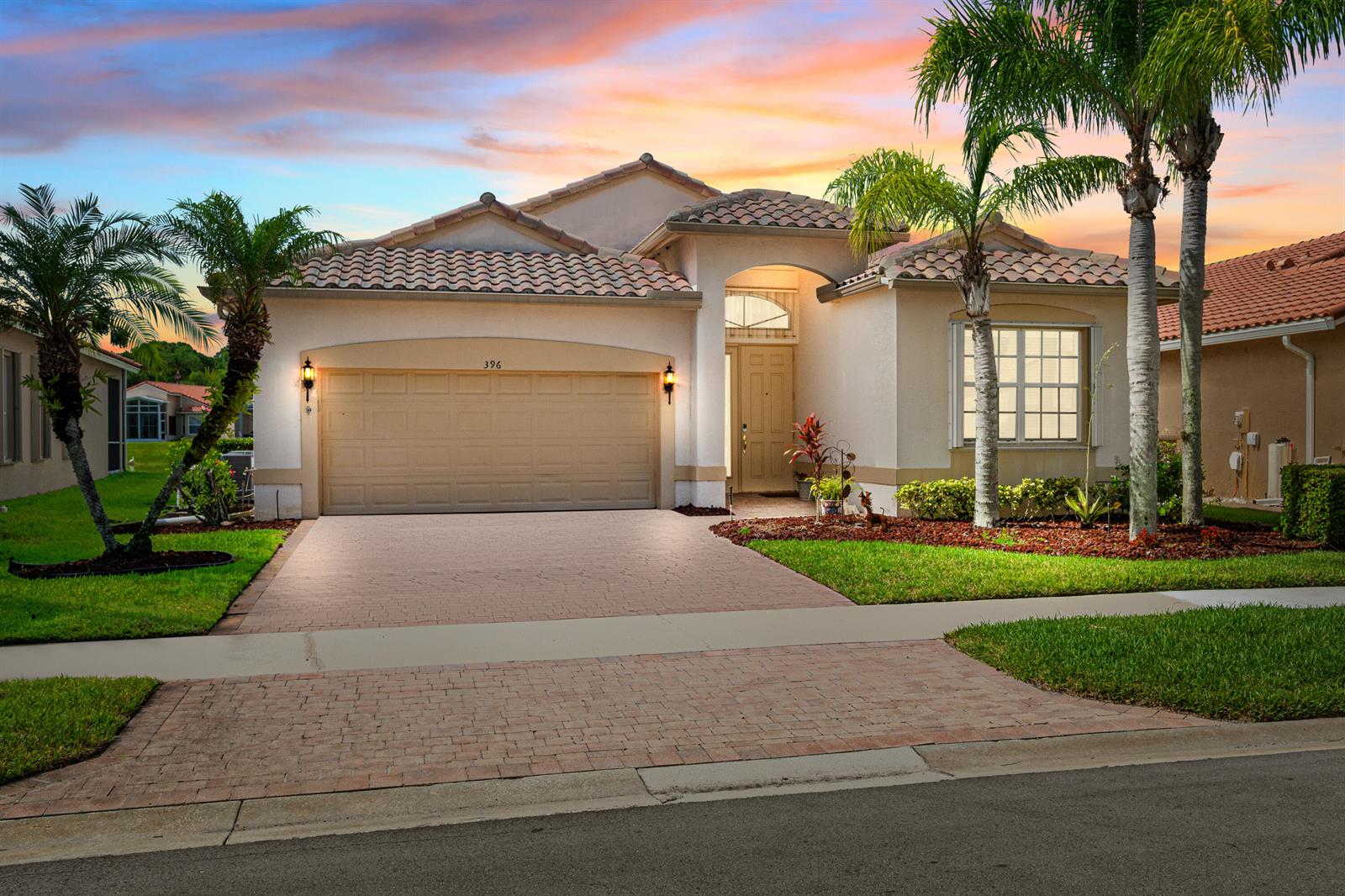 A single-story house with a beige stucco exterior, tile roof, and a paved driveway — 396 NW SPRINGVIEW Loop, Port St. Lucie FL 34986, PORT ST. LUCIE, FL