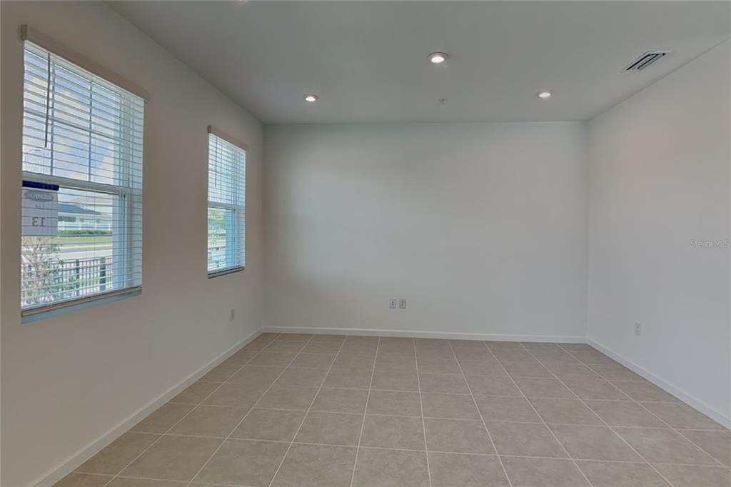An empty room with white walls, tile flooring, recessed lighting, and two windows — 4216 SADLER ROAD, APOPKA, FL