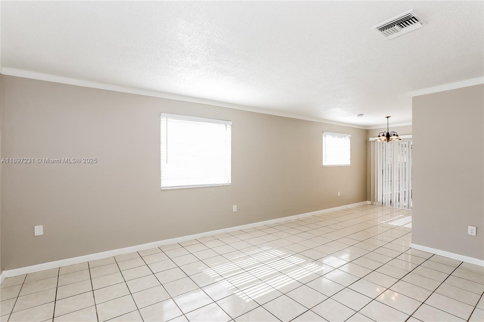 A bright, empty room features beige walls, white tile flooring, and two windows — 381 NE 164th St # 0, Miami FL 33162, MIAMI, FL
