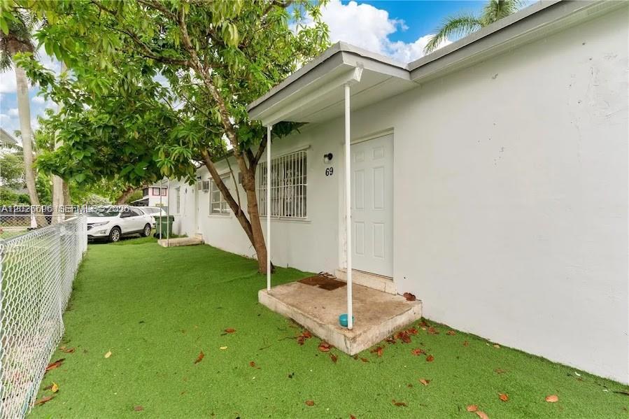 A white exterior wall with a small concrete porch and a single entry door — 69 NW 5th St, Homestead FL 33030, HOMESTEAD, FL
