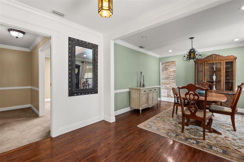 A dining room with hardwood floors, a wooden table, a hutch, and sage green walls — 2080 GOLDWATER COURT, MAITLAND, FL