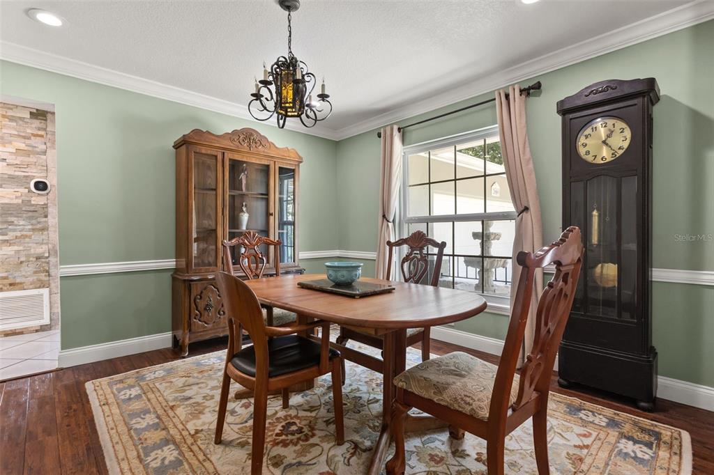 A dining room features a wooden table, chairs, a hutch, and a tall grandfather clock — 2080 GOLDWATER COURT, MAITLAND, FL