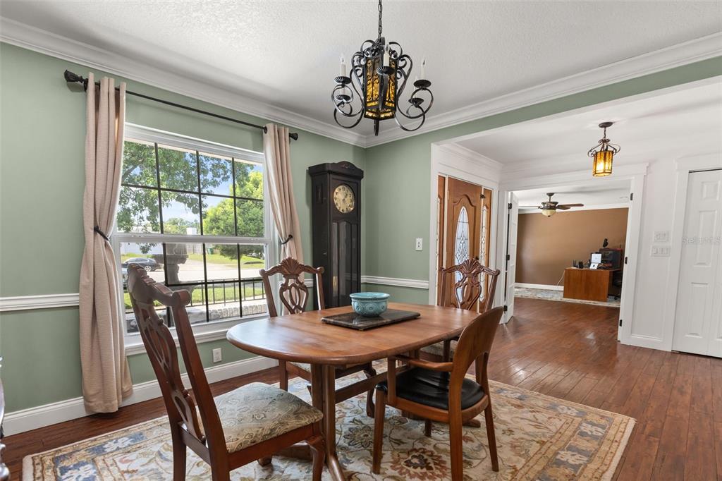 A dining room with sage green walls, a wooden table, and a grandfather clock — 2080 GOLDWATER COURT, MAITLAND, FL