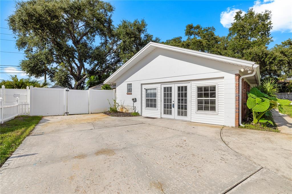 A detached white building with a concrete driveway and a white vinyl privacy fence — 13589 101ST TERRACE, SEMINOLE, FL