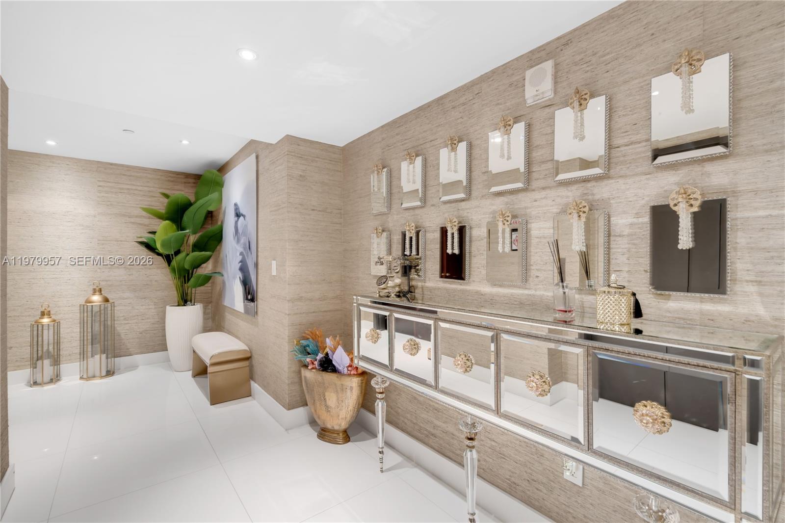 A hallway features a mirrored console table, wall-mounted mirrors, and textured wallpaper — 900 Biscayne Blvd, Miami FL 33132, MIAMI, FL