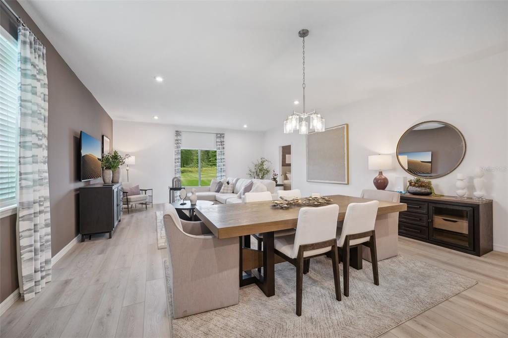 A dining area with a wooden table and chairs sits in front of a living room — 5816 CLIFFBOW LOOP, LEESBURG, FL