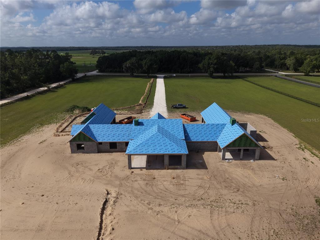An aerial view shows a house under construction with a dark metal roof — 14951 SE 60TH STREET, MORRISTON, FL