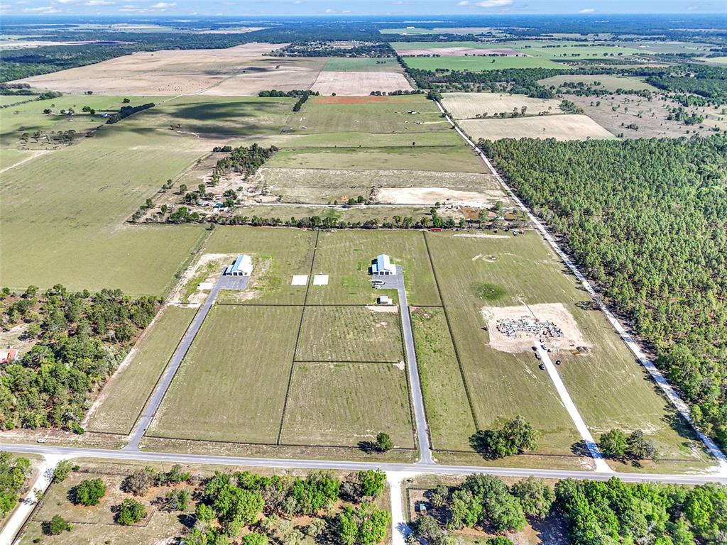 An aerial view shows a modern house under construction with a black metal roof — 14951 SE 60TH STREET, MORRISTON, FL