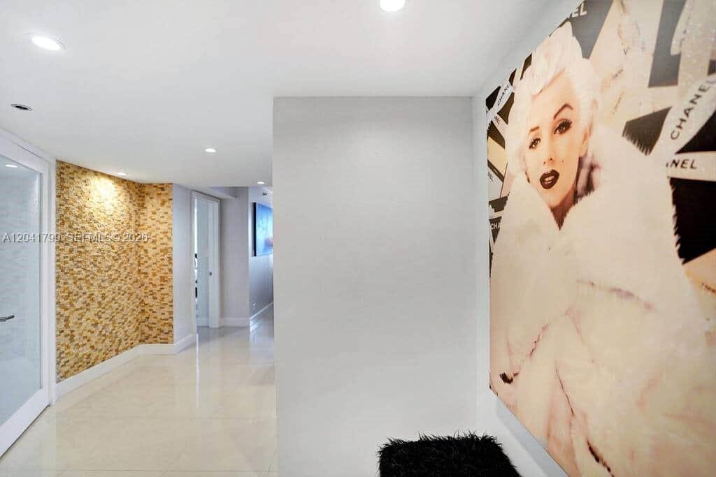 A hallway features a textured gold accent wall, white tile floors, and a Marilyn Monroe portrait — 1717 N Bayshore Dr # 2056, Miami FL 33132, MIAMI, FL