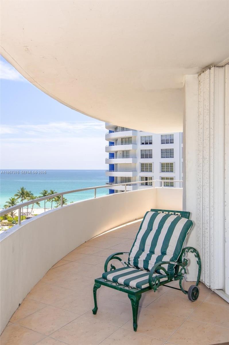 A balcony with a green and white striped lounge chair overlooks the ocean and beach — 5161 Collins Ave # 1104, Miami Beach FL 33140, MIAMI BEACH, FL