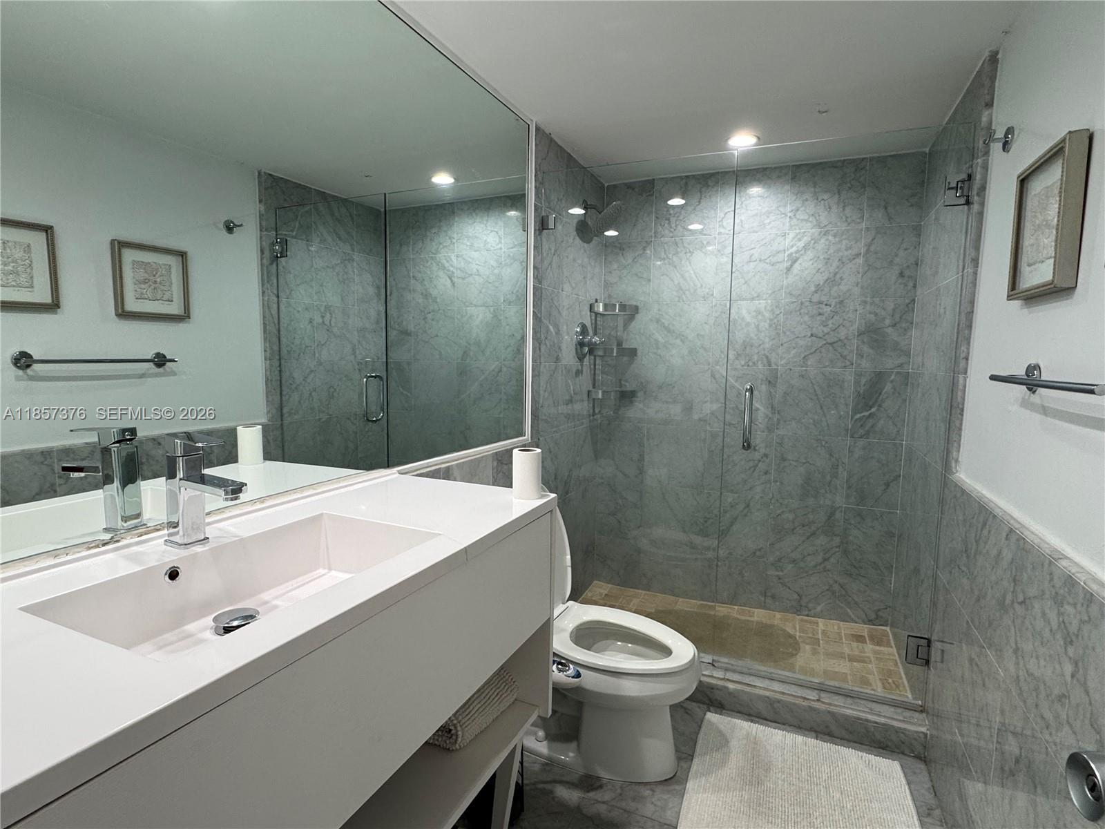 A bathroom features a white vanity, a toilet with a bidet, and a glass-enclosed shower — 5161 Collins Ave # 1104, Miami Beach FL 33140, MIAMI BEACH, FL